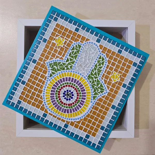 Hamsa Hand Mosaic resting diagonally in open white box